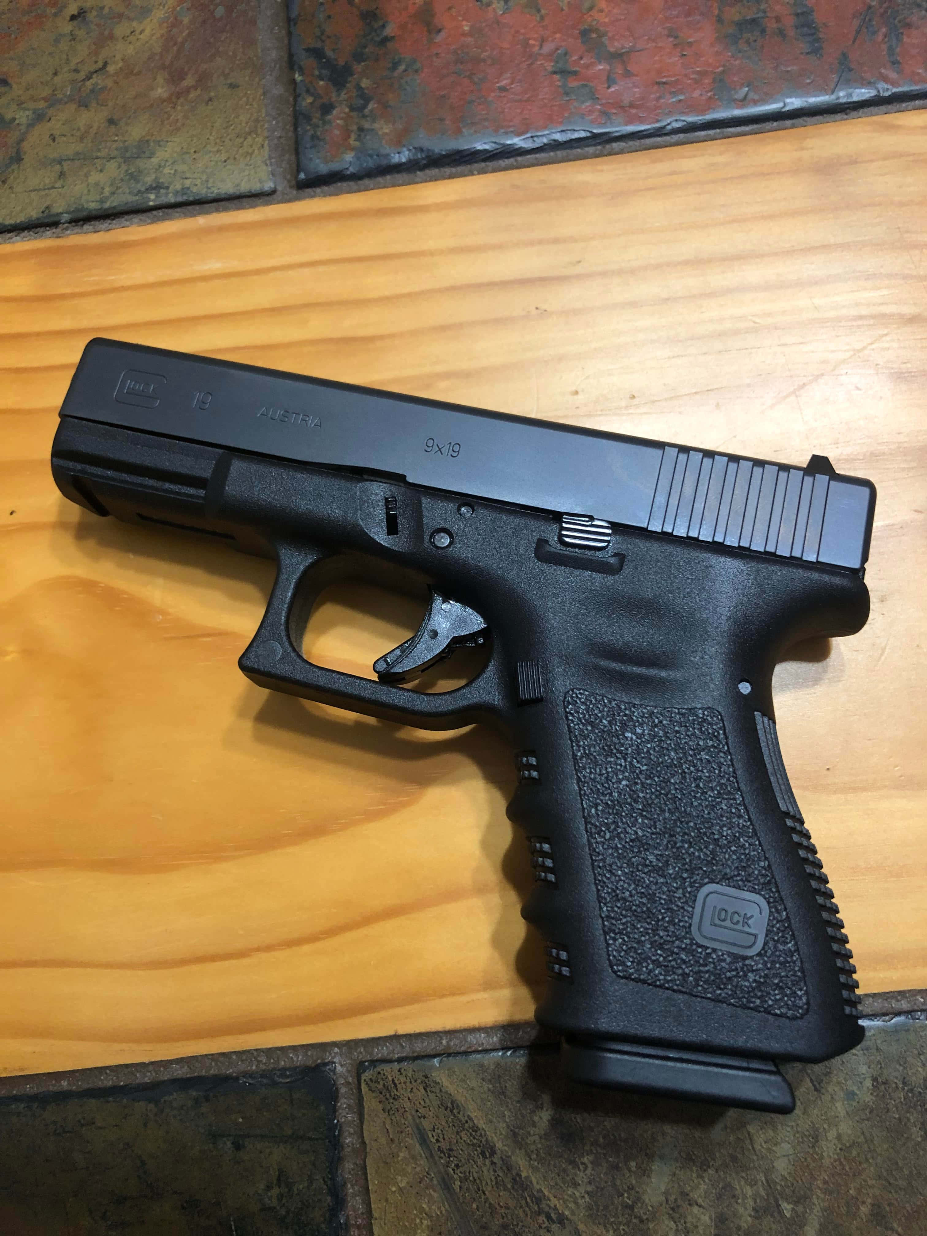 ένα μαύρο πιστόλι glock σε ξύλινο πάτωμα Ταπετσαρία