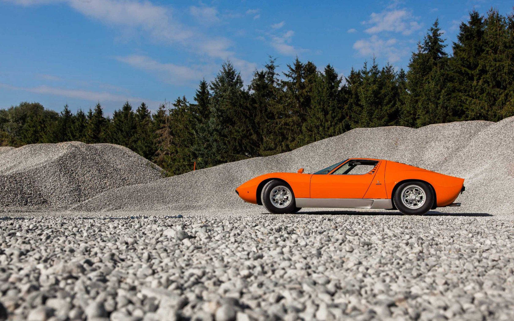 Μια εξαίσια πορτοκαλί Lamborghini Miura σε χωματόδρομο. Ταπετσαρία
