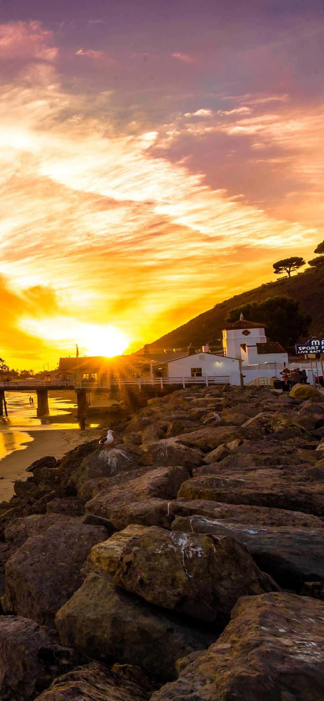 Οι χρυσαφένιες αμμουδιές του Malibu φαίνονται ακόμα καλύτερες πίσω από την οθόνη ενός iPhone Xs Ταπετσαρία
