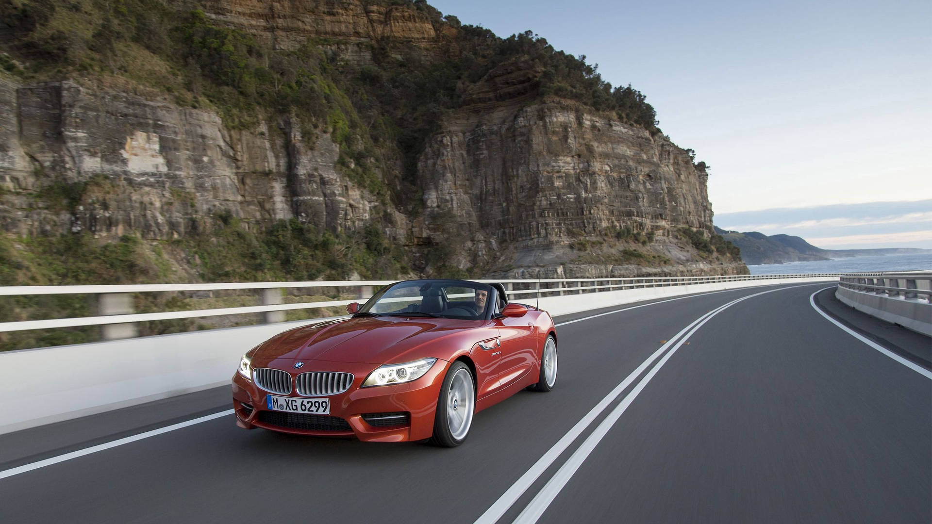 Πορτοκαλί BMW Z4 σε δρόμο δίπλα σε βουνό ταπετσαρία — Bmw Ταπετσαρία