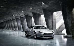 Aston Martin DB9 να διασχίζει ένα γραφικό αστικό τοπίο — Steam Deck OLED Ταπετσαρία