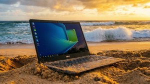 Ένα Chromebook ακουμπισμένο σε αμμώδη παραλία κατά τη διάρκεια ενός εντυπωσιακού ηλιοβασιλέματος.