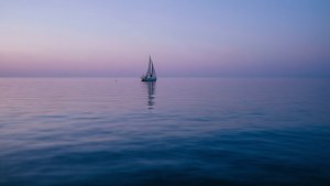 Ένα μοναχικό ιστιοφόρο σε ήρεμα θαλασσινά νερά το σούρουπο. — Ωκεανός Ταπετσαρία