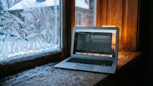 Ένα MacBook Air σε ένα χιονισμένο περβάζι με ζεστό εσωτερικό φωτισμό. — MacBook Ταπετσαρία