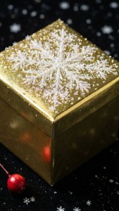 Γυαλιστερό χρυσό δώρο με νιφάδες χιονιού σε μαύρη επιφάνεια με μούρο. — iPhone 7 Ταπετσαρία